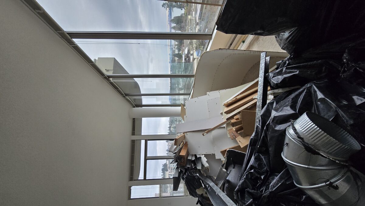 Condo living room during demolition — construction debris removal with panoramic ocean views, West Vancouver