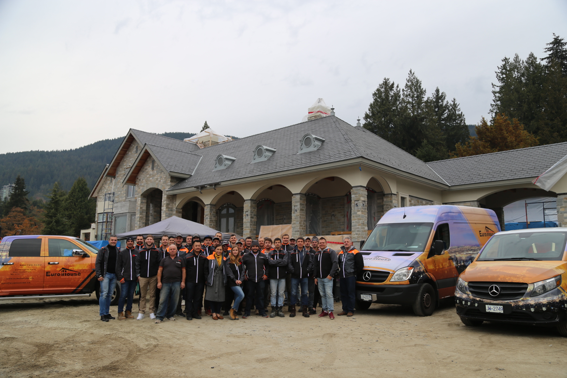Eurohouse Construction full team on site at a luxury residential project in West Vancouver — branded vehicles and crew in Eurohouse uniforms