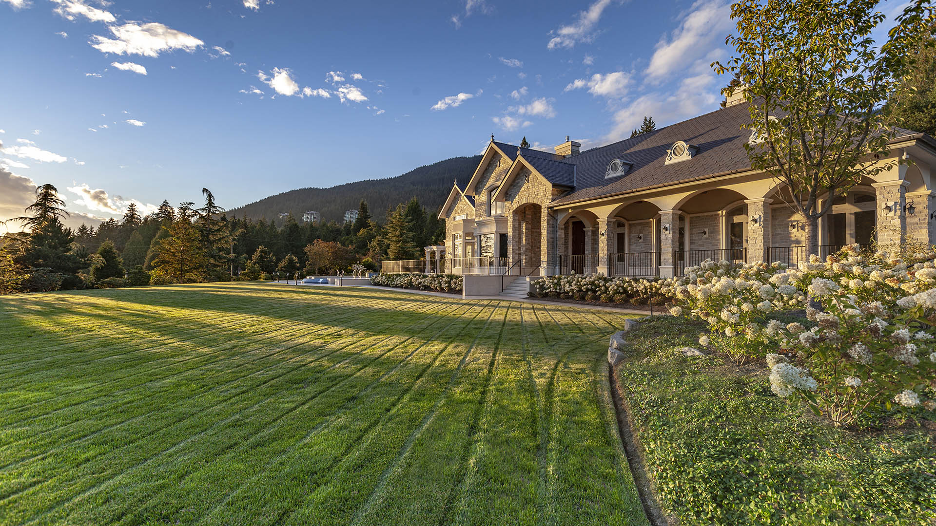 Altamont's Muse side exterior with arched colonnade and mountain views in West Vancouver