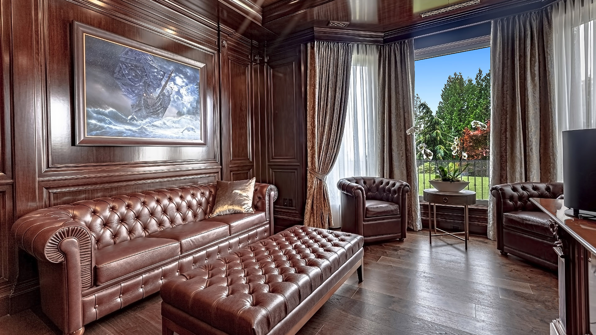 Altamont's Muse library sitting area with tufted leather and garden views in West Vancouver