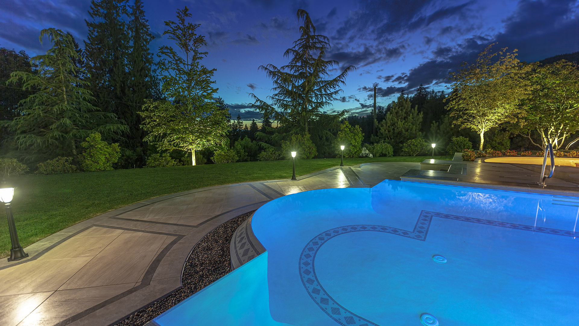 Altamont's Muse pool at twilight with LED accent lighting and landscaping in West Vancouver