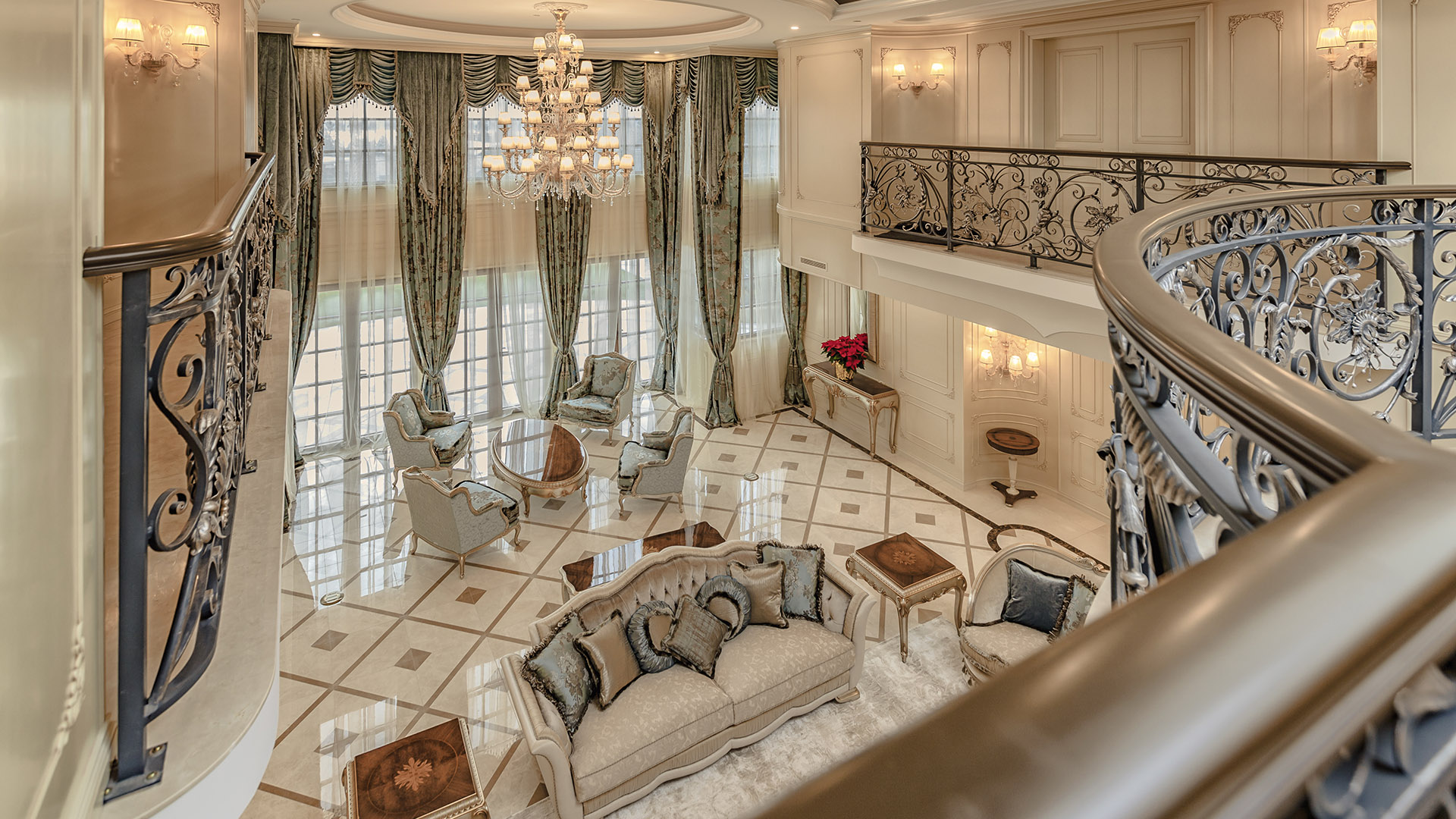 Ambleside Palace living room aerial view from curved marble staircase with wrought iron balustrade in West Vancouver