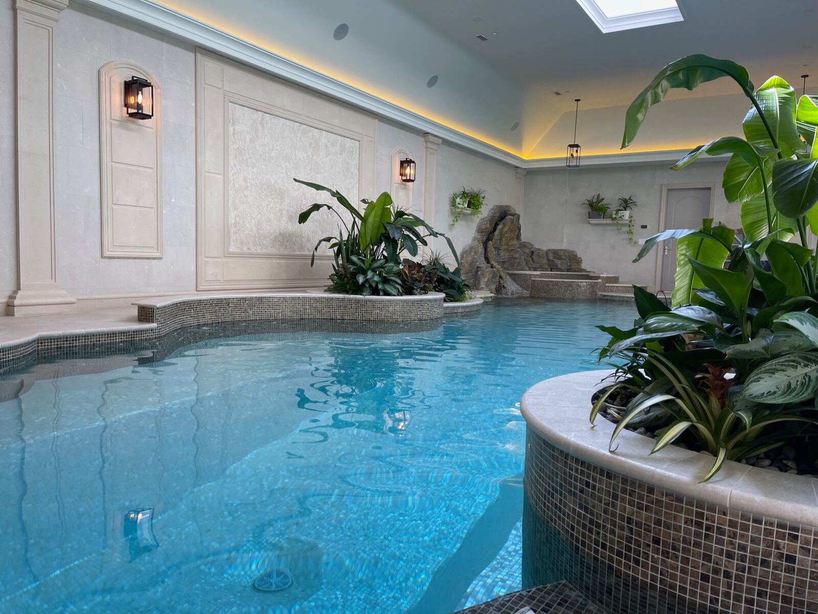 Indoor pool with classical wall paneling and lantern sconces