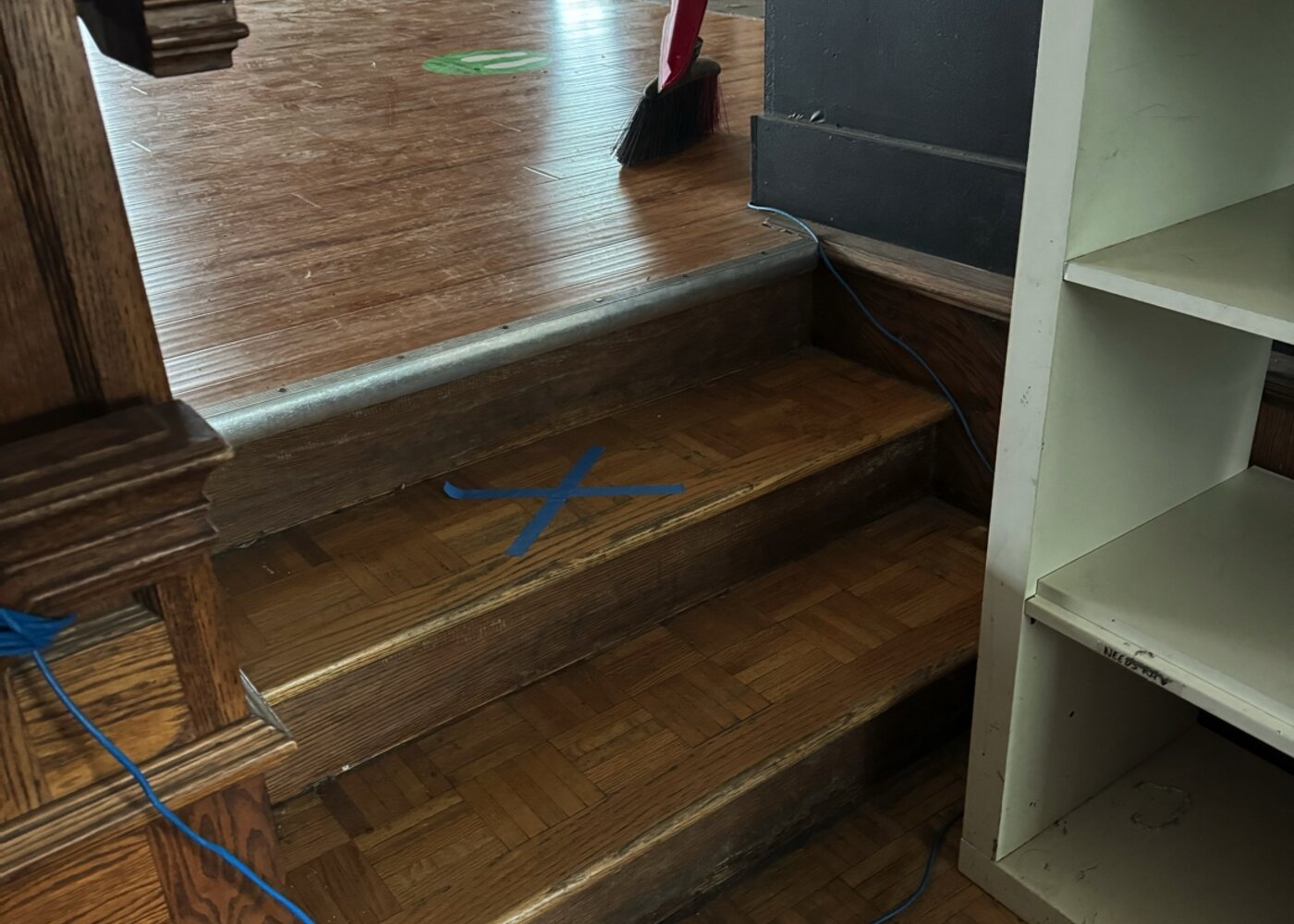 Water-damaged parquet stairs and landing requiring full replacement in commercial retail space