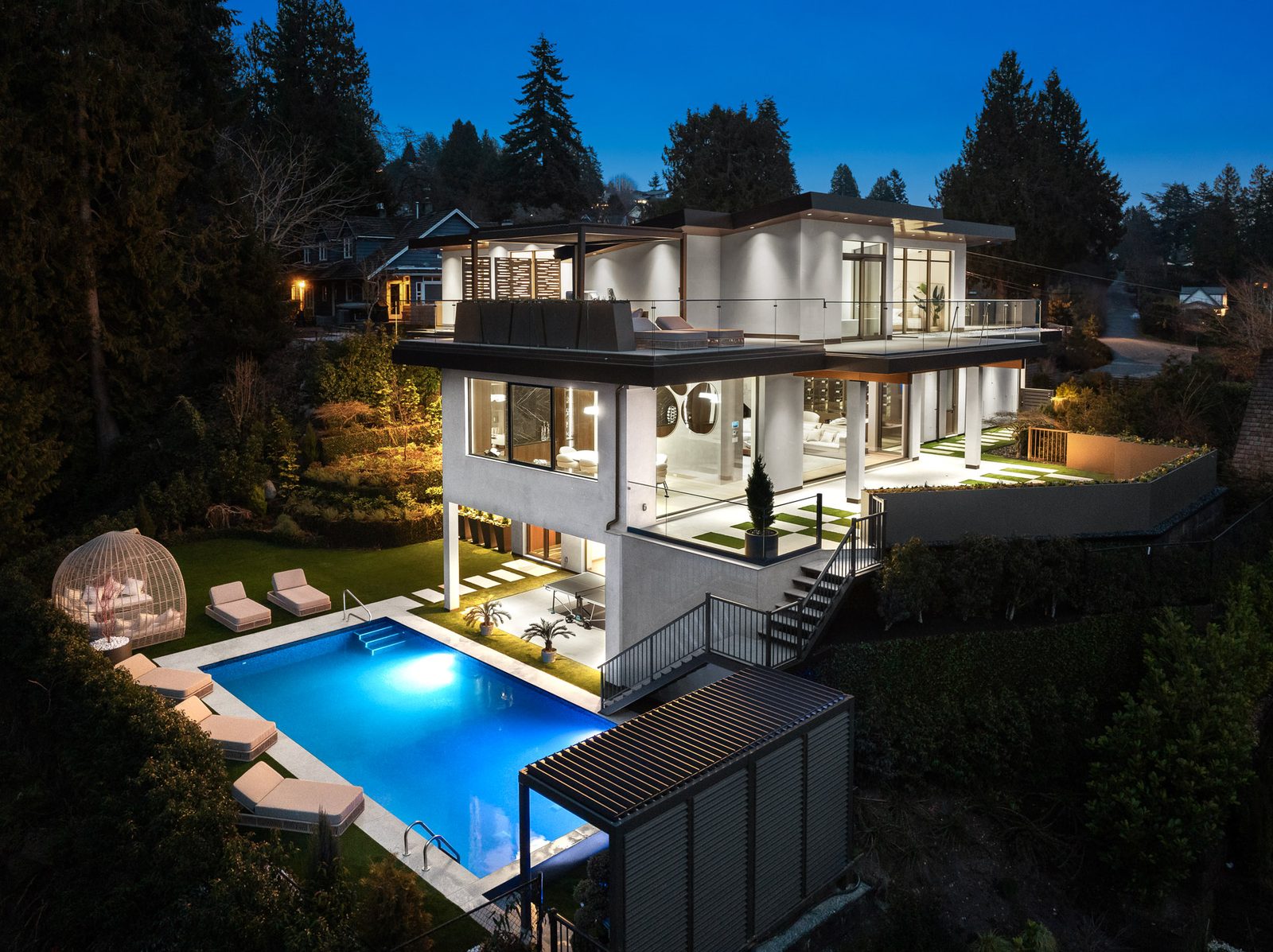 Butterfly roofline contemporary luxury residence at dusk in Altamont West Vancouver by Eurohouse Construction