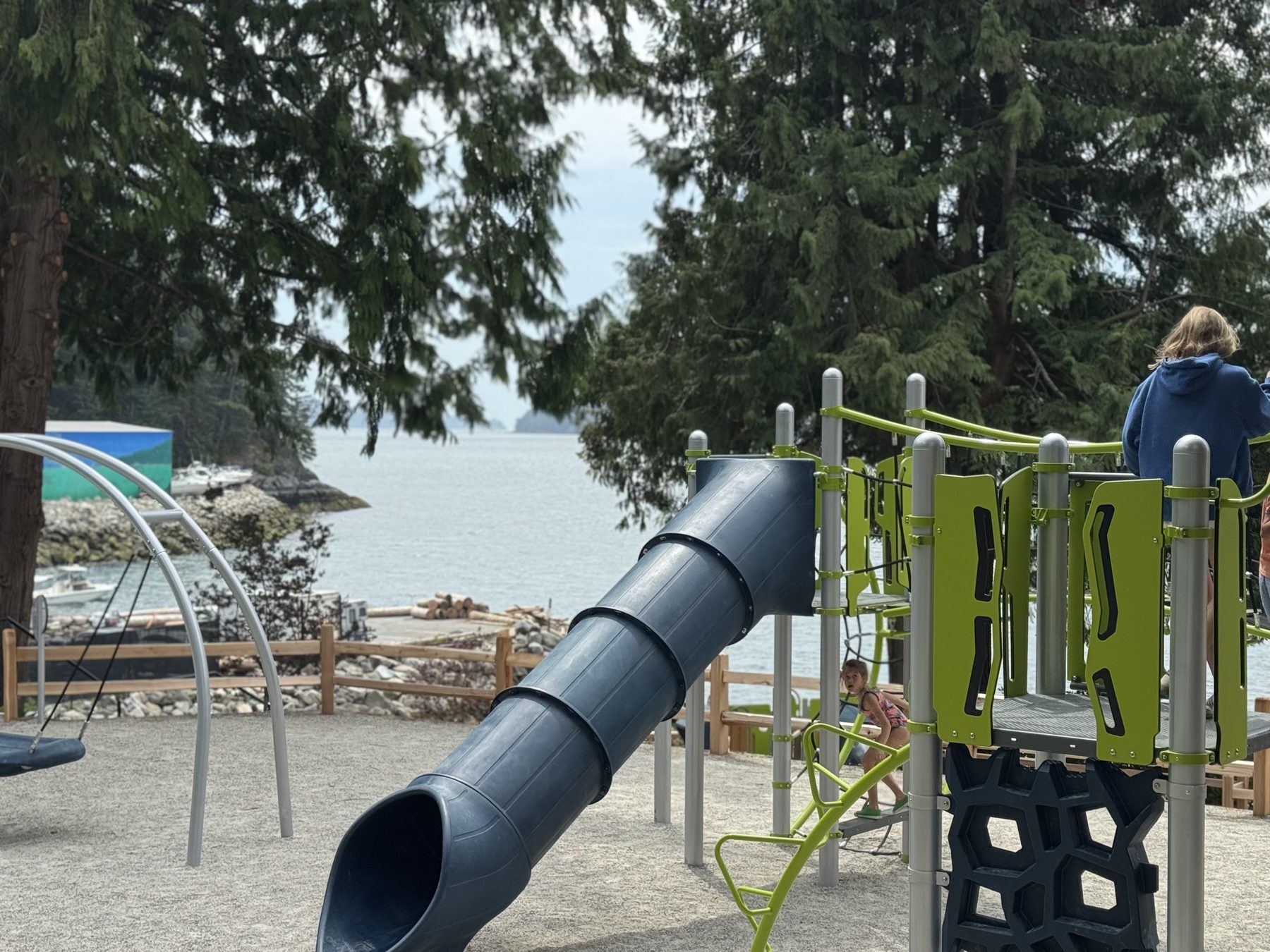 New playground at Lions Bay Beach Park with slide and Howe Sound shoreline
