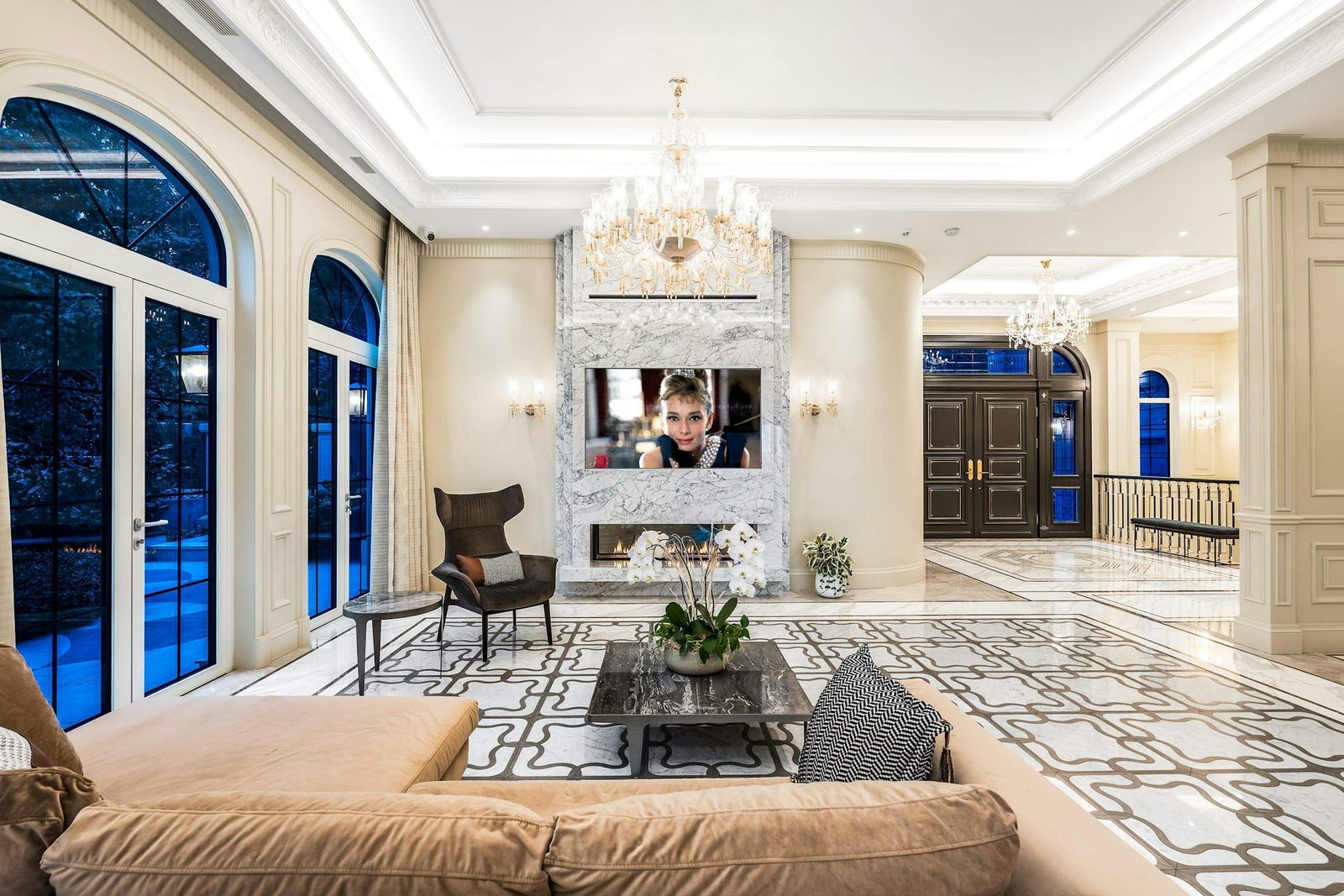 Living room with marble fireplace surround and crystal chandelier in luxury West Vancouver estate