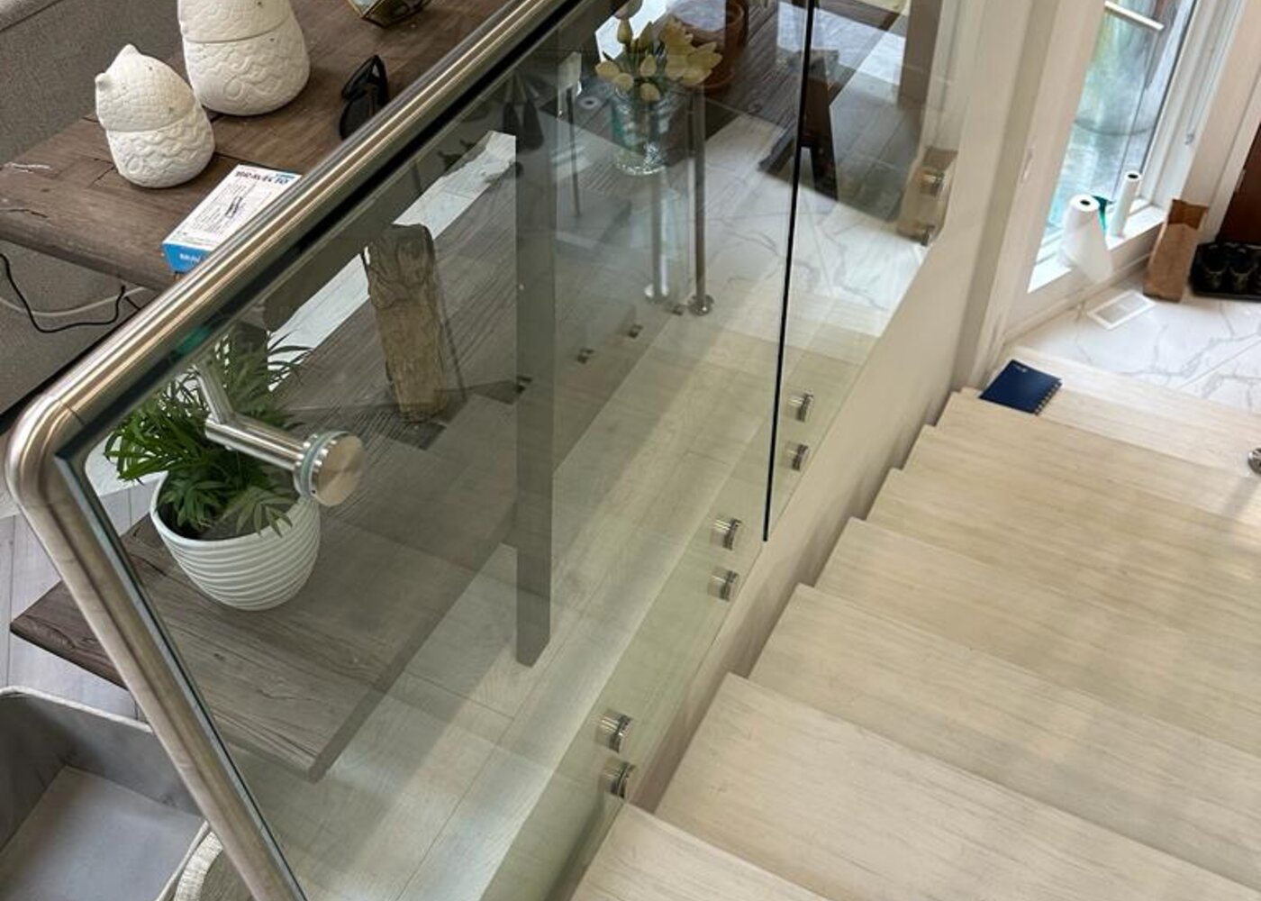 Entry level staircase with glass railings and marble floor before storm damage at Prospect Road North Vancouver