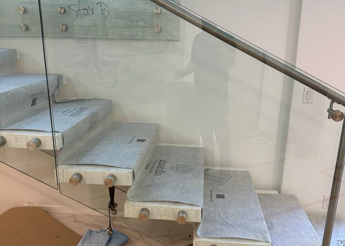 Stair treads with protective covering before restoration at Prospect Road North Vancouver