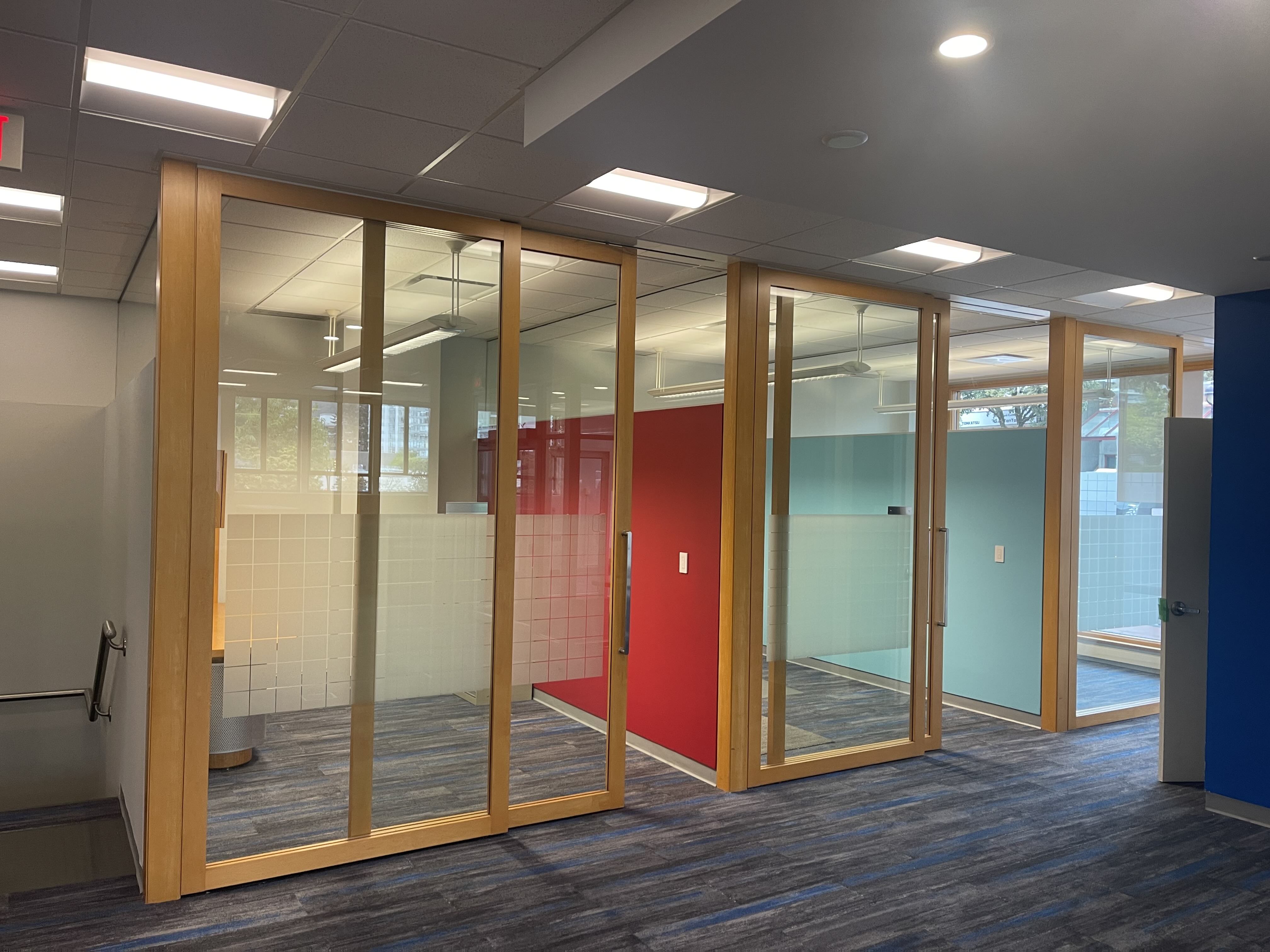 12mm glass partitions with wood-framed doors — Rennie office interior West Vancouver, built by Eurohouse Construction