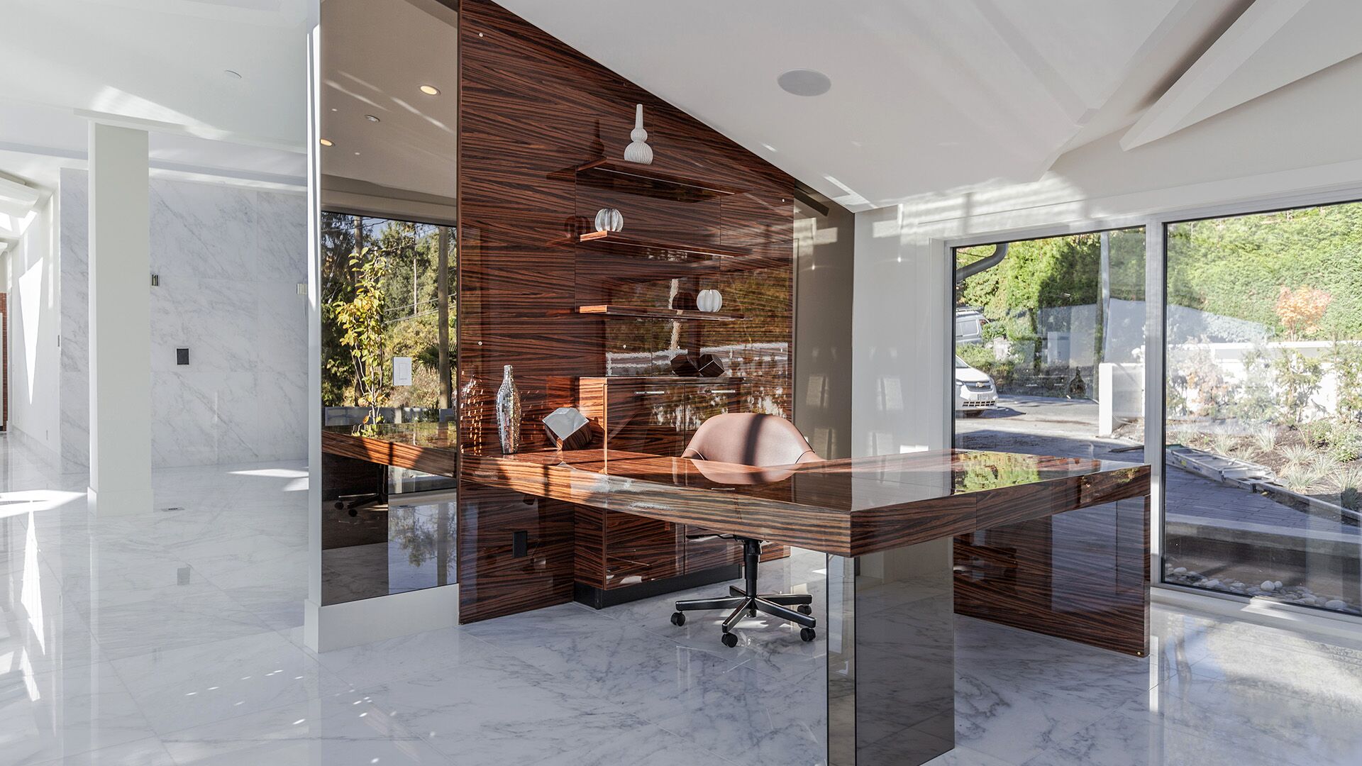 Zebrawood study with cantilevered floating desk glass partition shelving and garden views at The Riva Club designed and installed by Eurohouse Construction