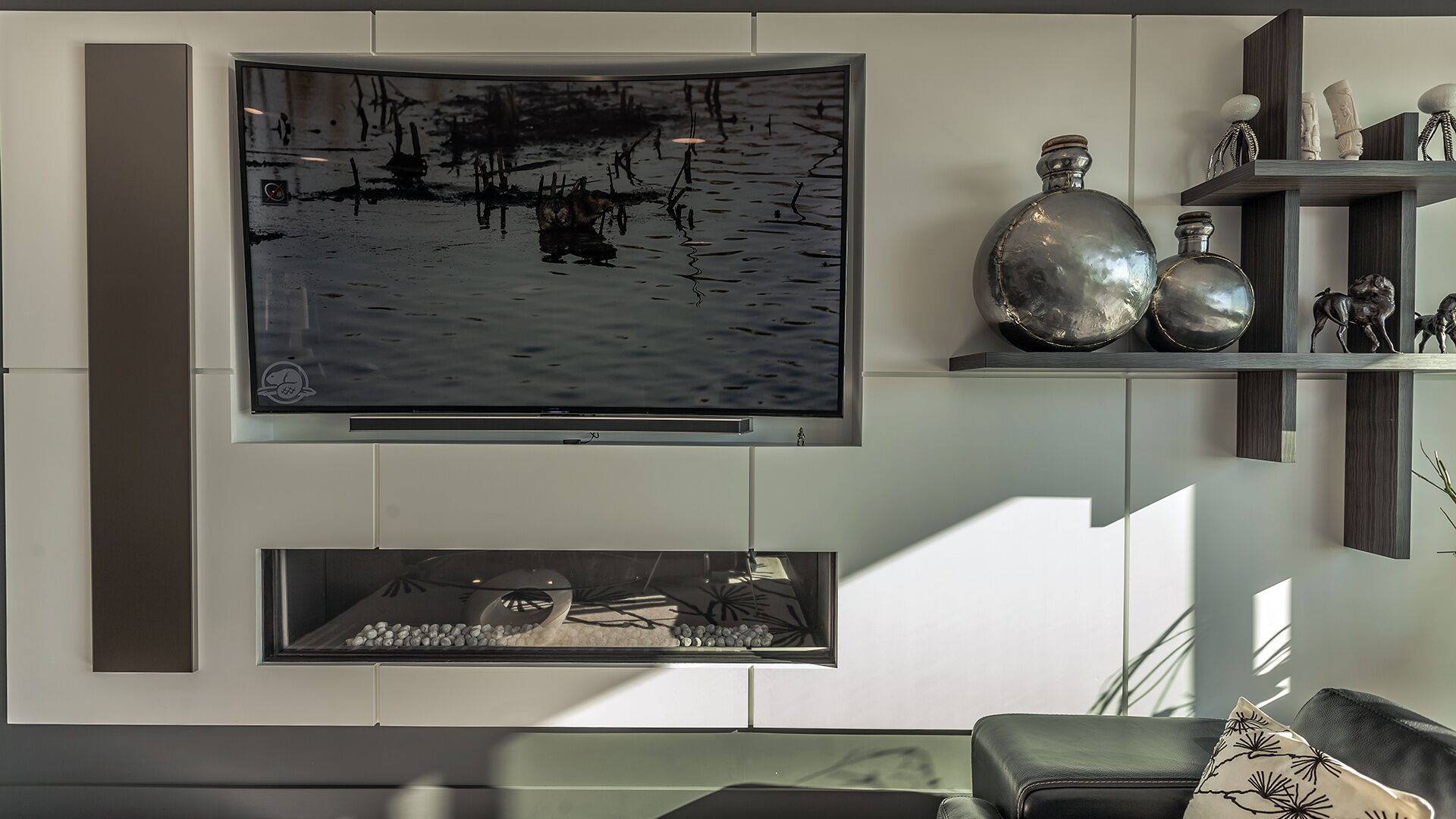 Custom media wall detail with integrated linear fireplace curved television floating dark wood display shelves and Italian built-in cabinetry at The Zen on Bramwell renovated by Eurohouse Construction