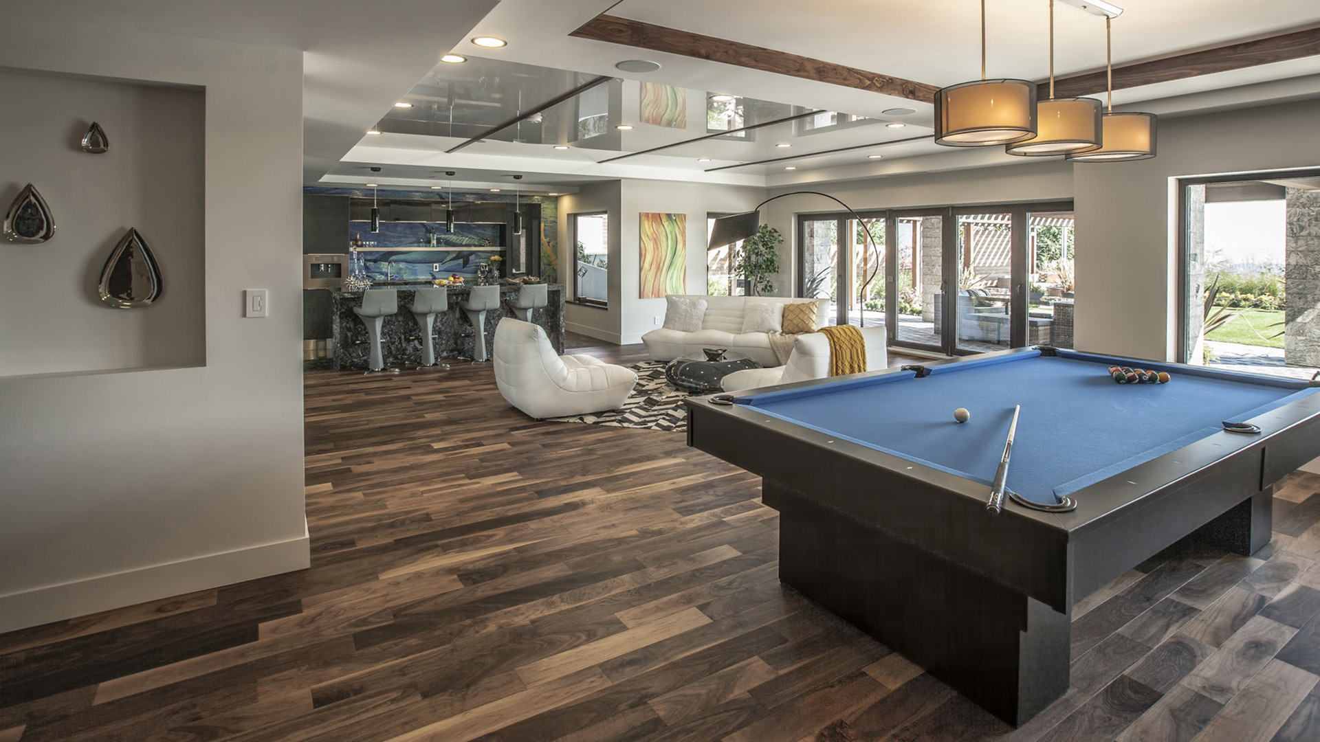 Rec room showing pool table designer pendant lighting colorful mosaic bar and walnut flooring with pool views West Coast Contemporary British Properties